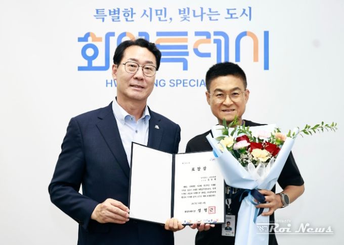 정명근 화성특례시장(좌)과 정동헌 주무관(우)이 기념촬영을 하고 있다